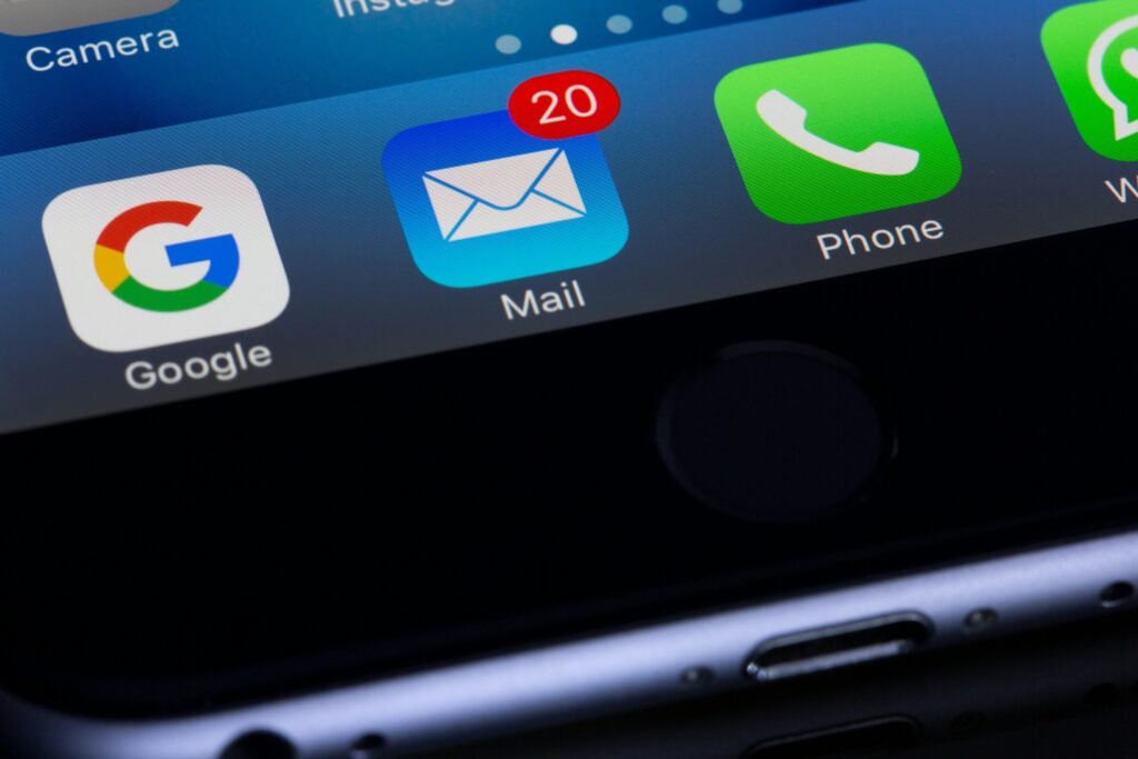 home page. A close-up photo of a smartphone displaying popular apps like Google and Mail.